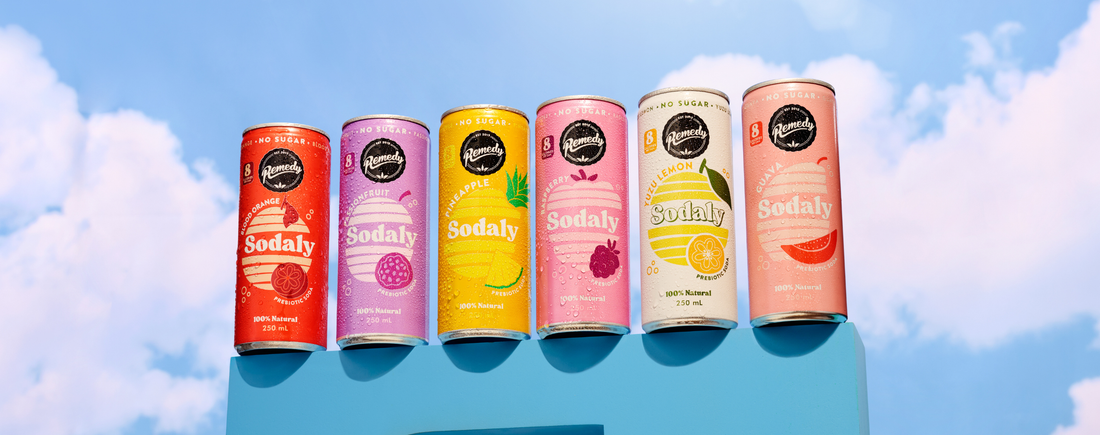 Cans of Sodaly in a row: Blood Orange, Passionfruit, Pineapple, Raspberry, Yuzu Lemon and Guava.